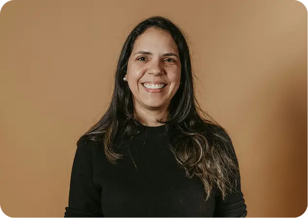 smiling woman in black sweater holding a plate of food