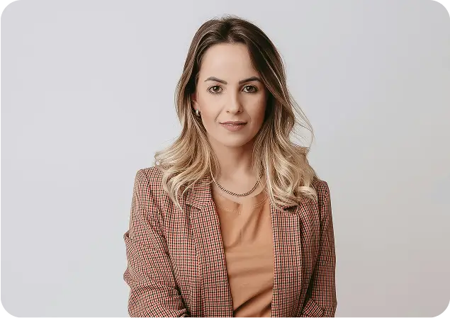 a woman in a brown jacket and tan top posing for a picture