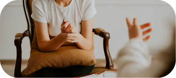 there is a woman sitting in a chair talking to a woman