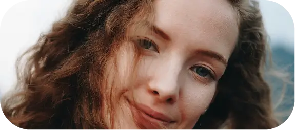 there is a woman with long hair smiling and looking at the camera